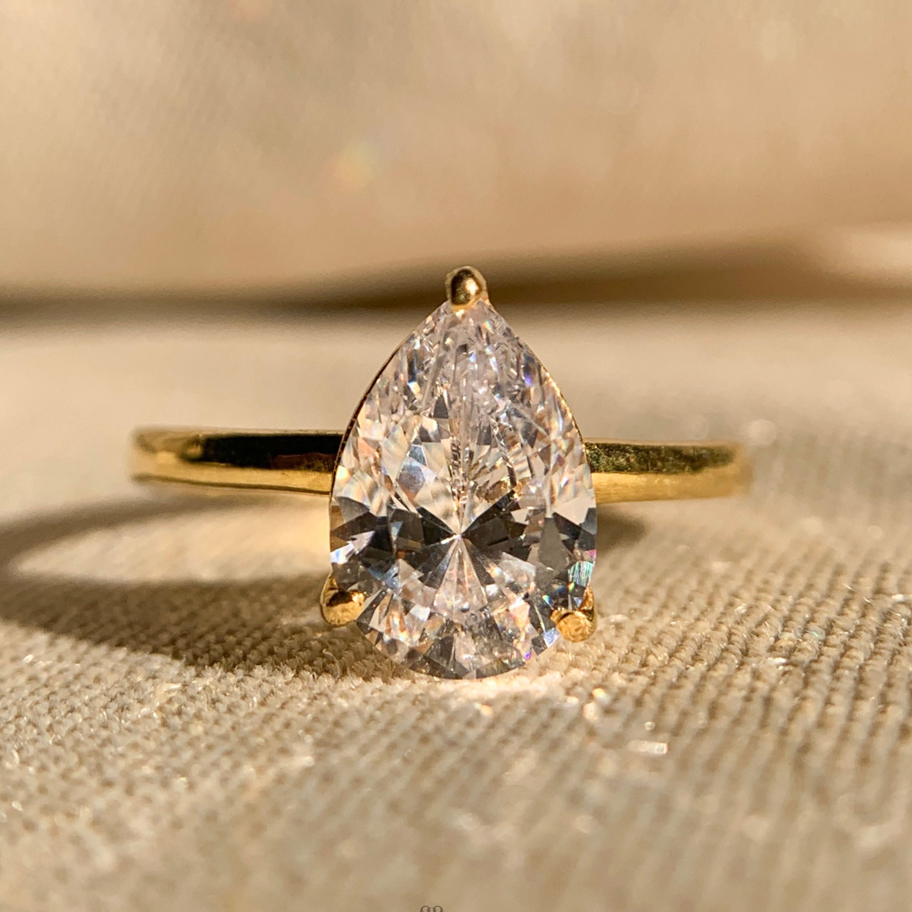 Moissanite pear shaped solitaire engagement ring in classic white gold setting